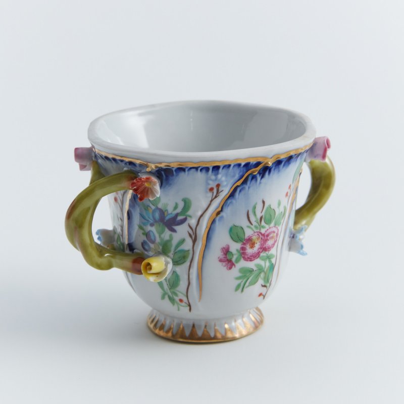 Старинная чашка с двумя ручками с лепными цветами.
