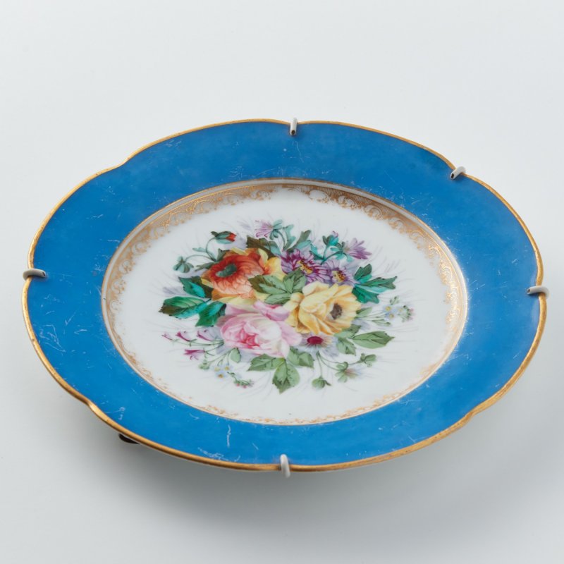 Старинная тарелка с бортом синего цвета и цветочной росписью.