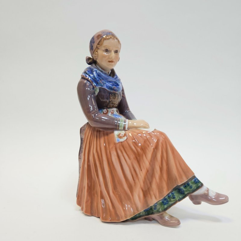 Фигурка сидящей молодой женщины в национальном костюме