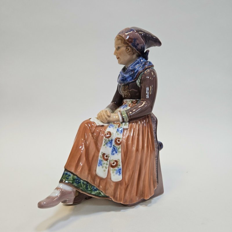 Фигурка сидящей молодой женщины в национальном костюме
