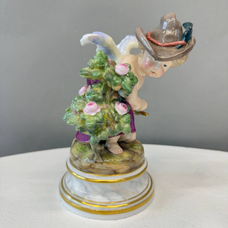 Фарфоровая статуэтка мануфактуры Meissen серии амуров, созданная по модели скульптора Генриха Швабе (Heinrich Schwabe) — «Амур как грабитель» или «Амур с шляпой» (Amor als Räuber hinter einem Rosenstrauch,  модель № L 106