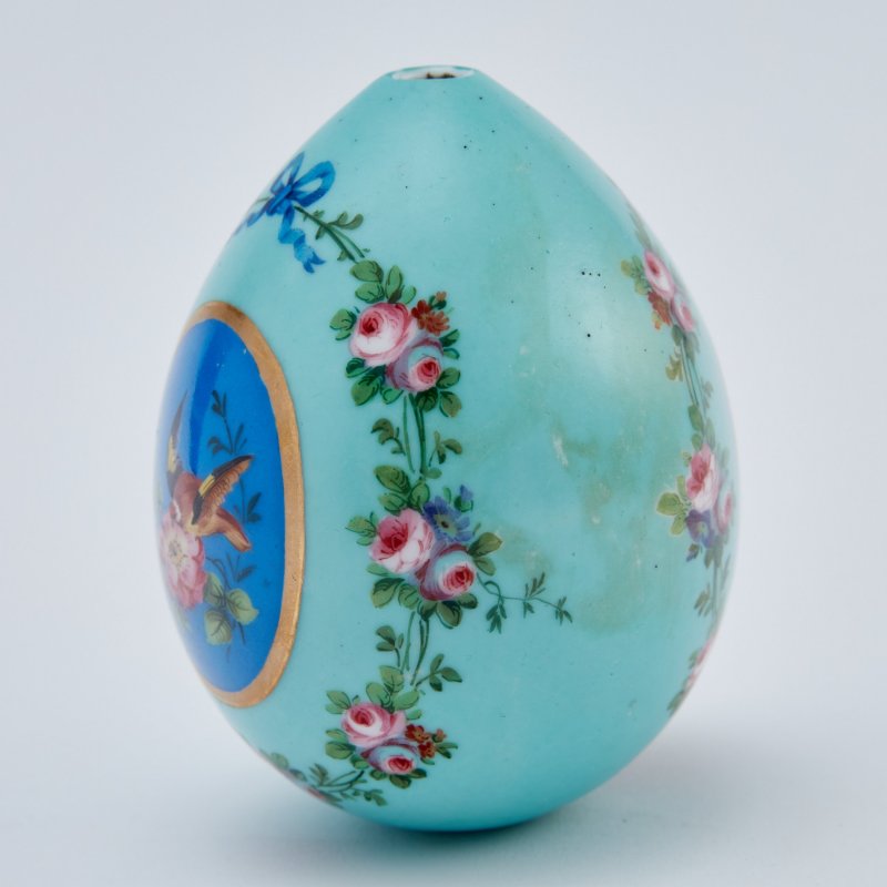 Фарфоровое пасхальное яйцо с изображением птиц в резервах и цветочными гирляндами.