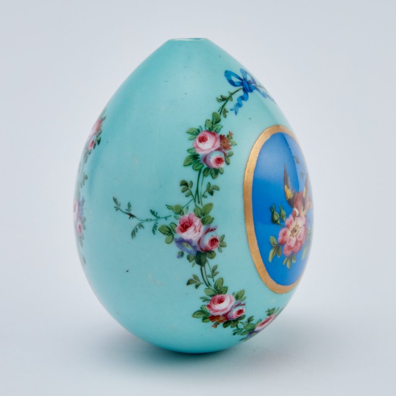 Фарфоровое пасхальное яйцо с изображением птиц в резервах и цветочными гирляндами.
